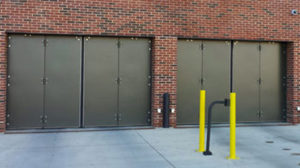 Brown metal four-fold industrial doors on a red brick building